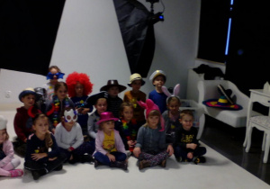 Dzieci ubrane w kapelusze, czapki, peruki pozują do pamiątkowego zdjęcia